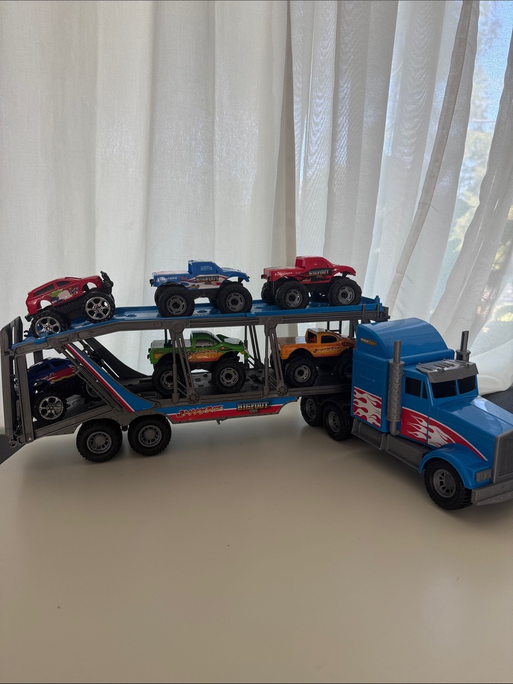 Blue Toy Car Transporter Truck with Six Colorful Monster Trucks